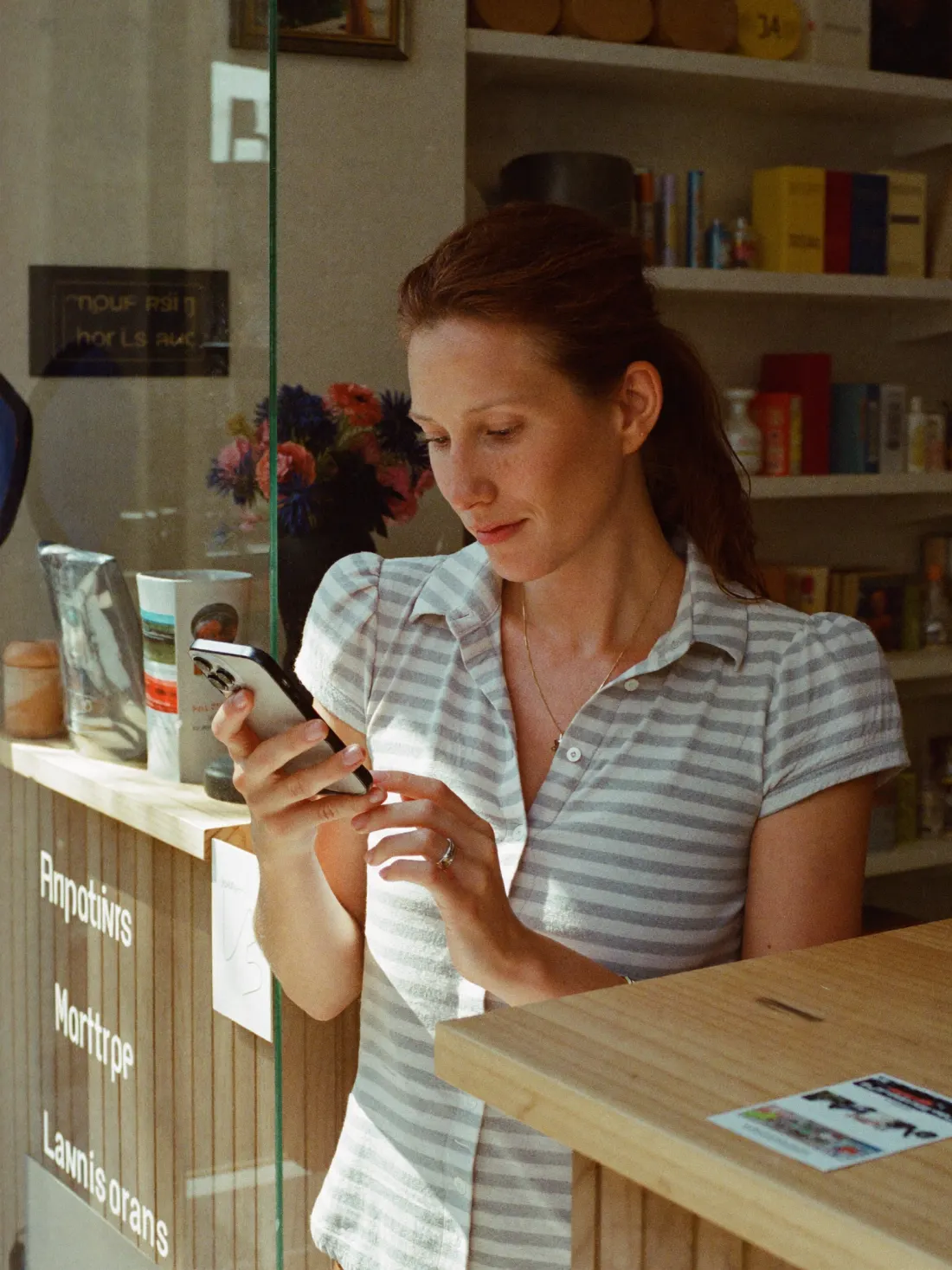 Commerçante dans sa boutique, téléphone en main